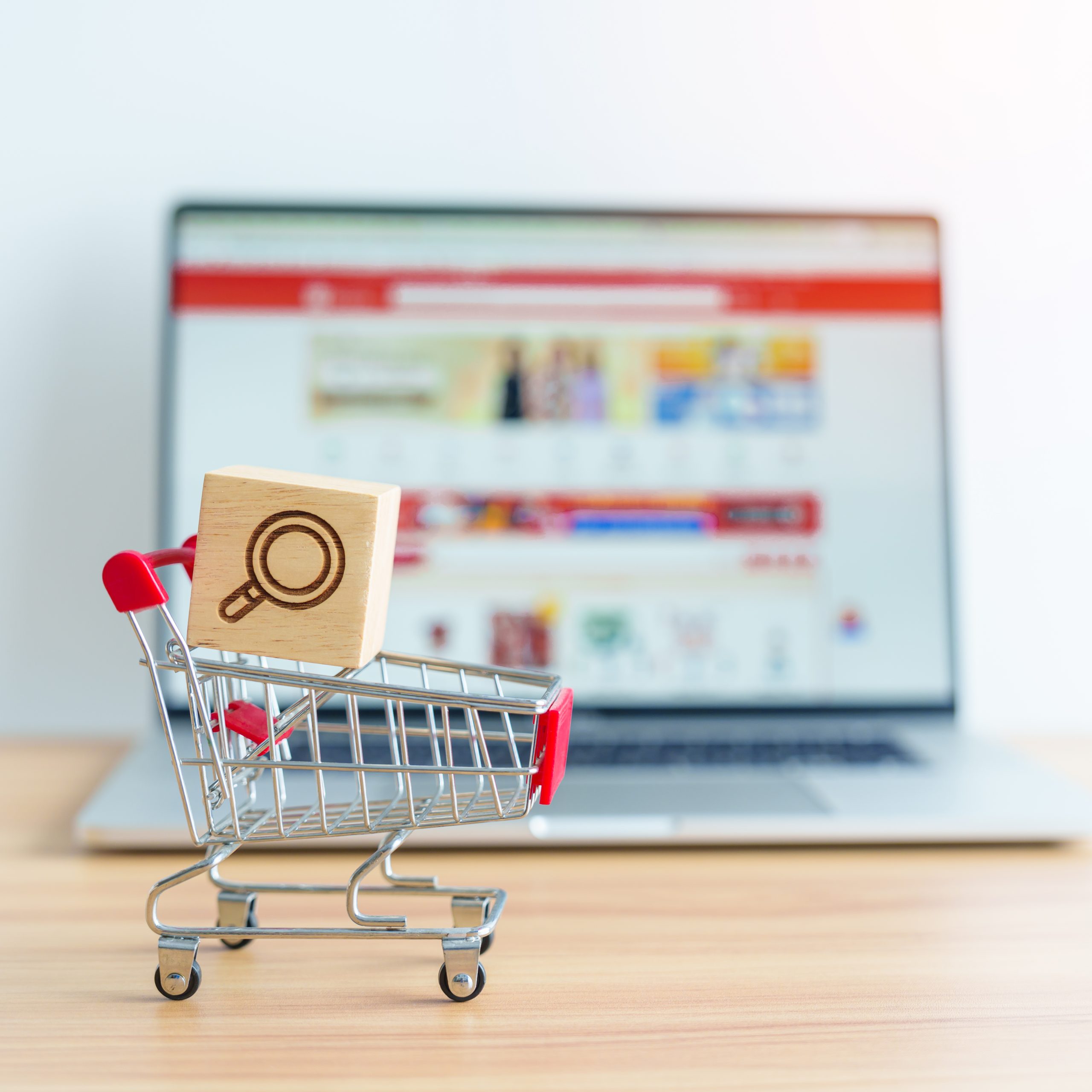 Shopping cart with Magnifying icon block and laptop computer with marketplace website, technology, ecommerce, SEO, Search Engine Optimization, Advertising, keyword and online payment concept